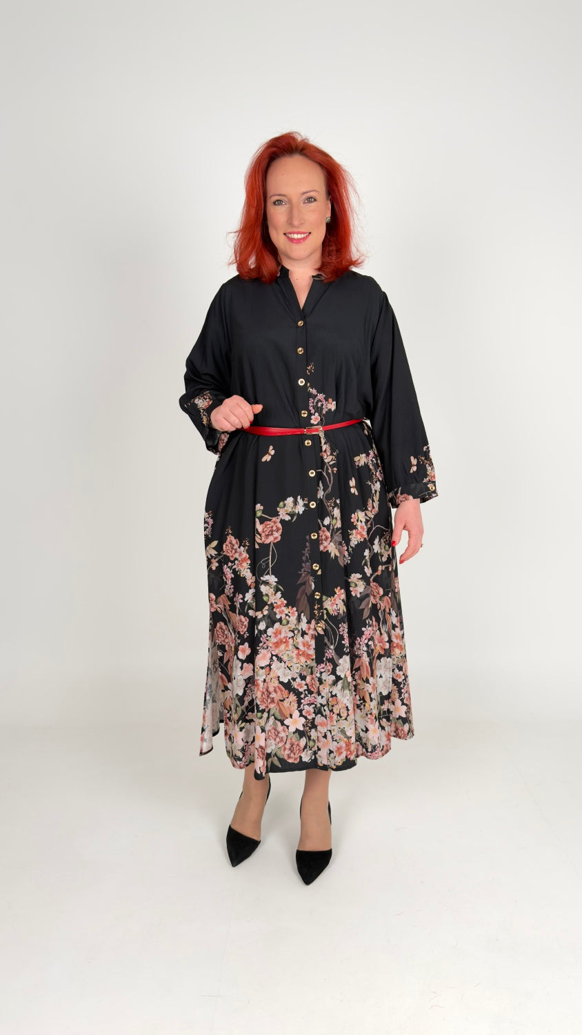 Sievišķīga kleita ar ziedu motīviem un jostu.