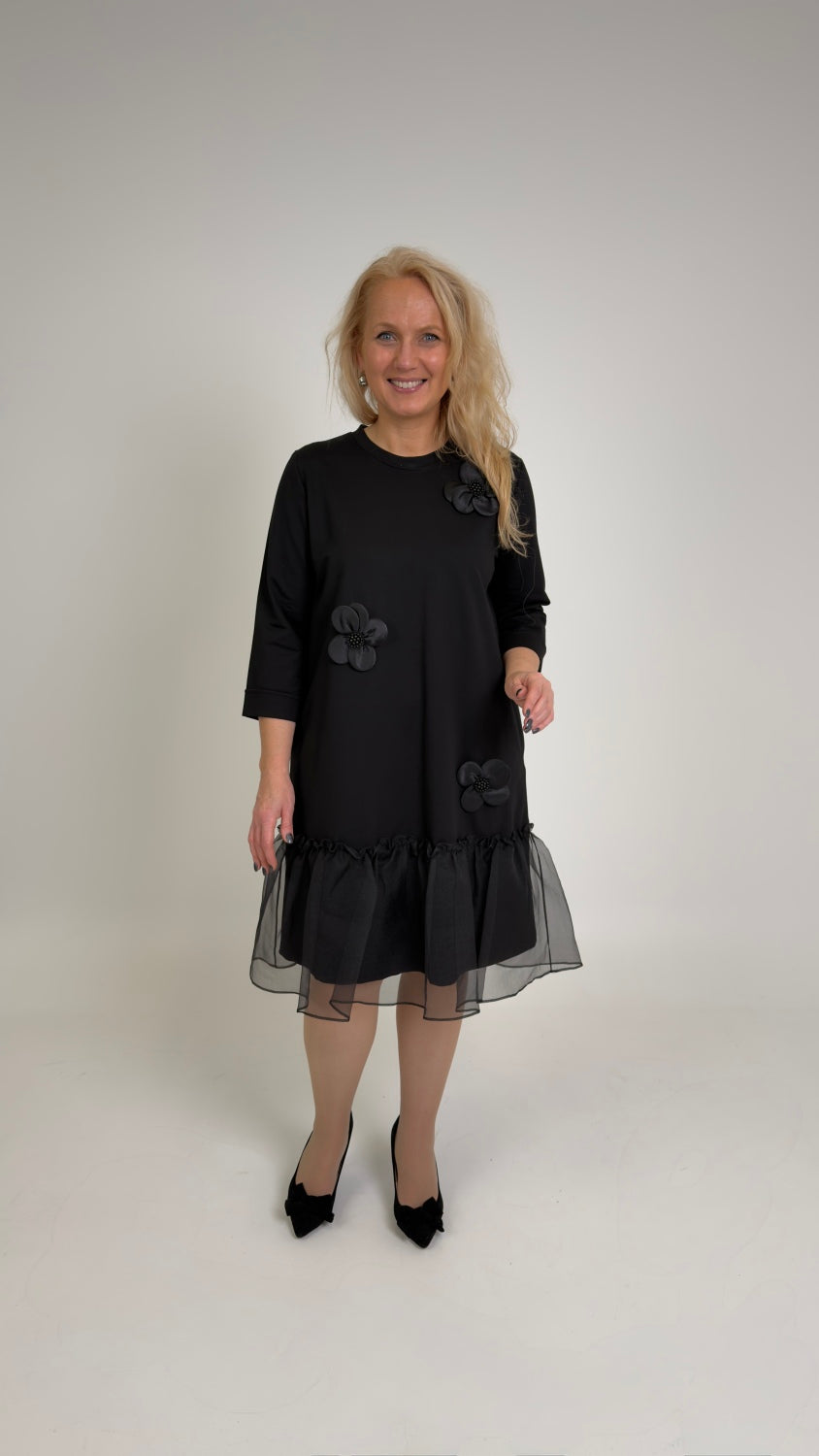 Melna kleita ar šifona volāniem un aplikācijām